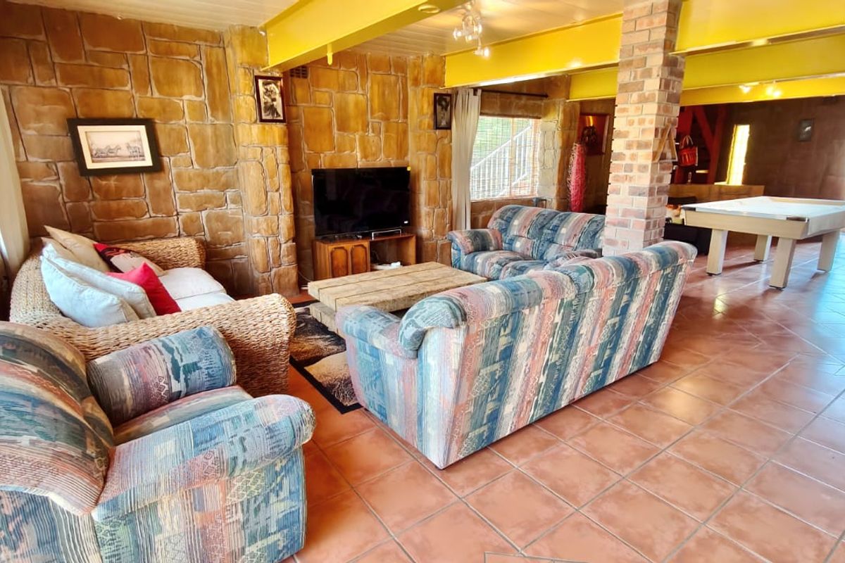 Spacious living area featuring rustic exposed brick walls, a central brick pillar, and durable ceramic tile flooring with an open-plan layout.