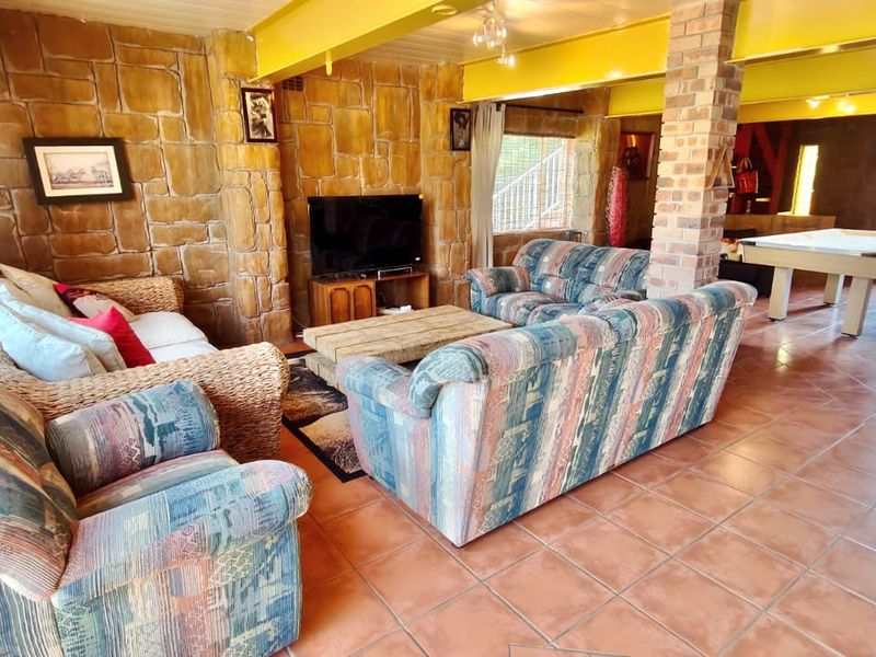 Spacious living area featuring rustic exposed brick walls, a central brick pillar, and durable ceramic tile flooring with an open-plan layout.