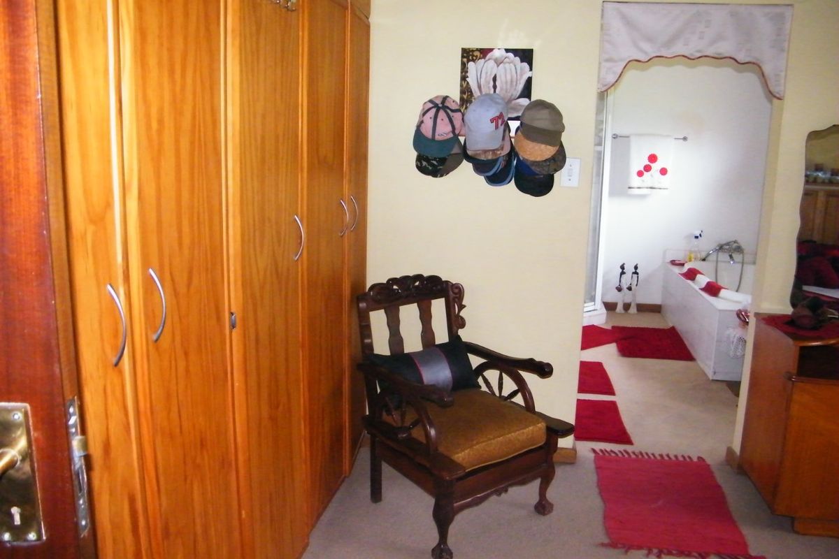 Bedroom featuring built-in wooden cupboards and direct access to an en-suite bathroom.
