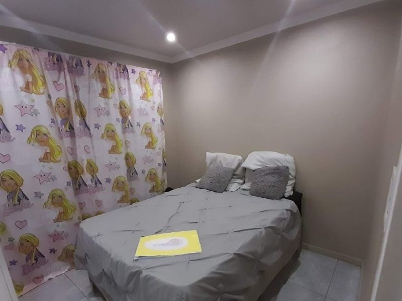 A compact bedroom featuring tiled flooring, recessed downlighting, and coved ceiling finishes.