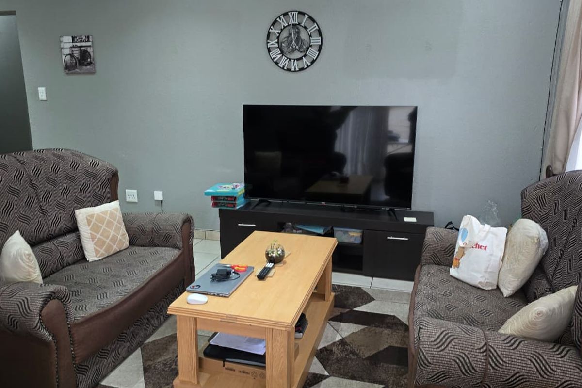 A comfortable living room area featuring tiled flooring and neutral wall finishes, providing a functional space for relaxation.