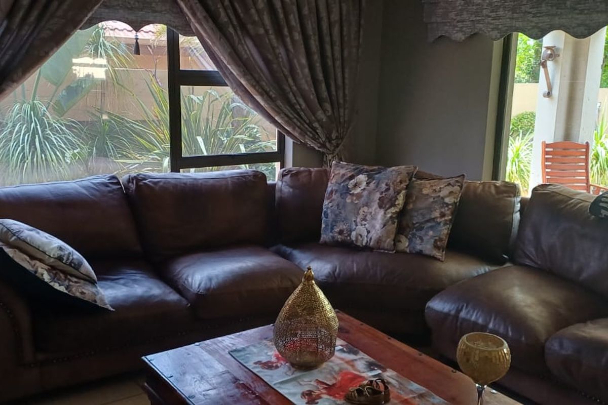 A comfortable living room featuring large windows and sliding glass doors that provide natural light and views of the outdoor area.