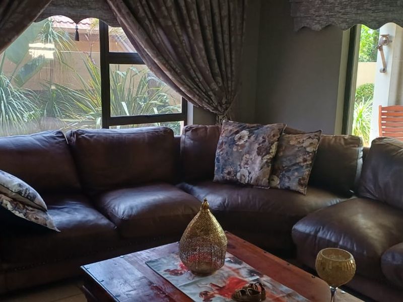 A comfortable living room featuring large windows and sliding glass doors that provide natural light and views of the outdoor area.