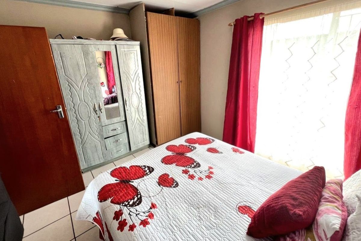 A bedroom featuring tiled flooring and a window with natural light.