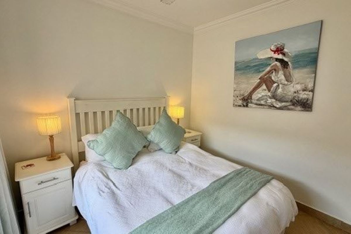 A well-maintained bedroom featuring crown molding and tiled flooring, providing a clean and comfortable living space.