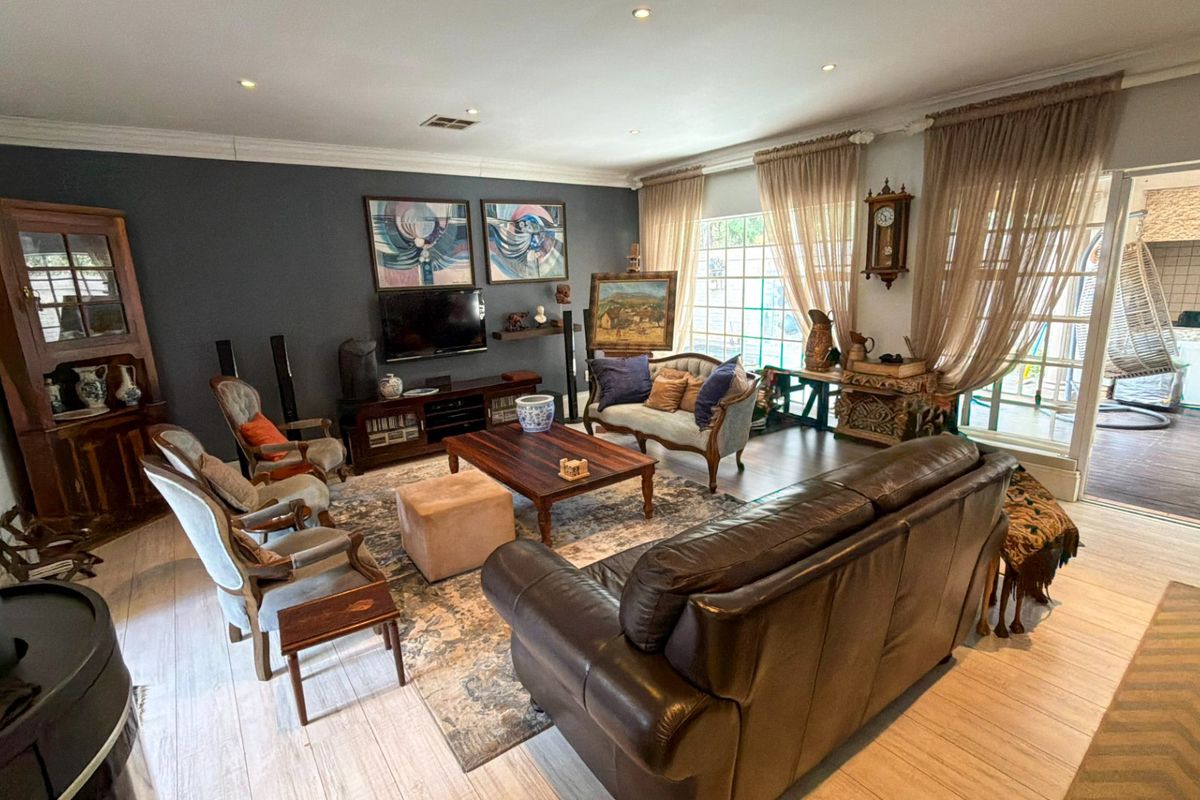 Spacious living room featuring wood-look tile flooring, crown molding, recessed lighting, and large sliding glass doors providing access to the outdoor patio area.