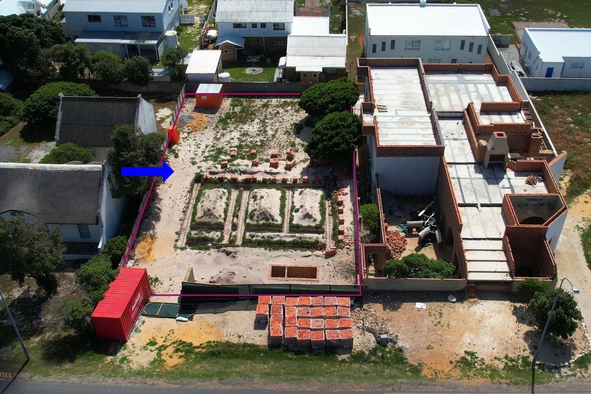 Aerial view of a residential property under construction, showing the building footprint, site boundaries, and ongoing masonry work.