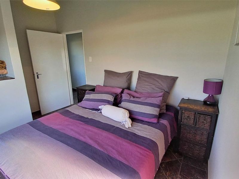 A functional bedroom featuring tiled flooring, neutral wall finishes, and a built-in alcove for storage.