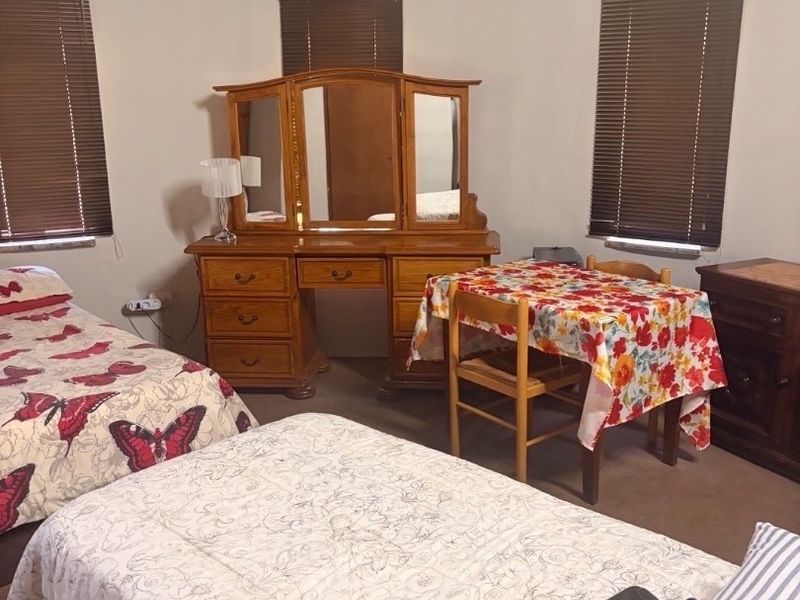 A bedroom featuring a unique thatched ceiling and multiple windows with fitted venetian blinds.