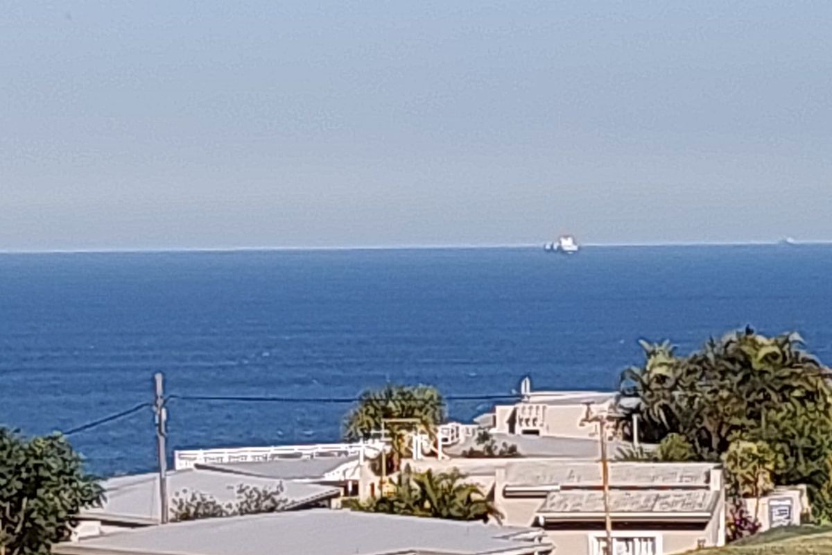 A scenic view overlooking the ocean and surrounding coastal residential properties.