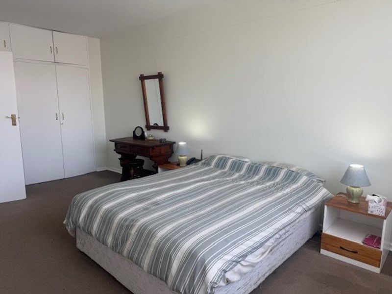 A functional bedroom featuring built-in cupboards and neutral wall finishes, offering a blank canvas for potential interior updates.