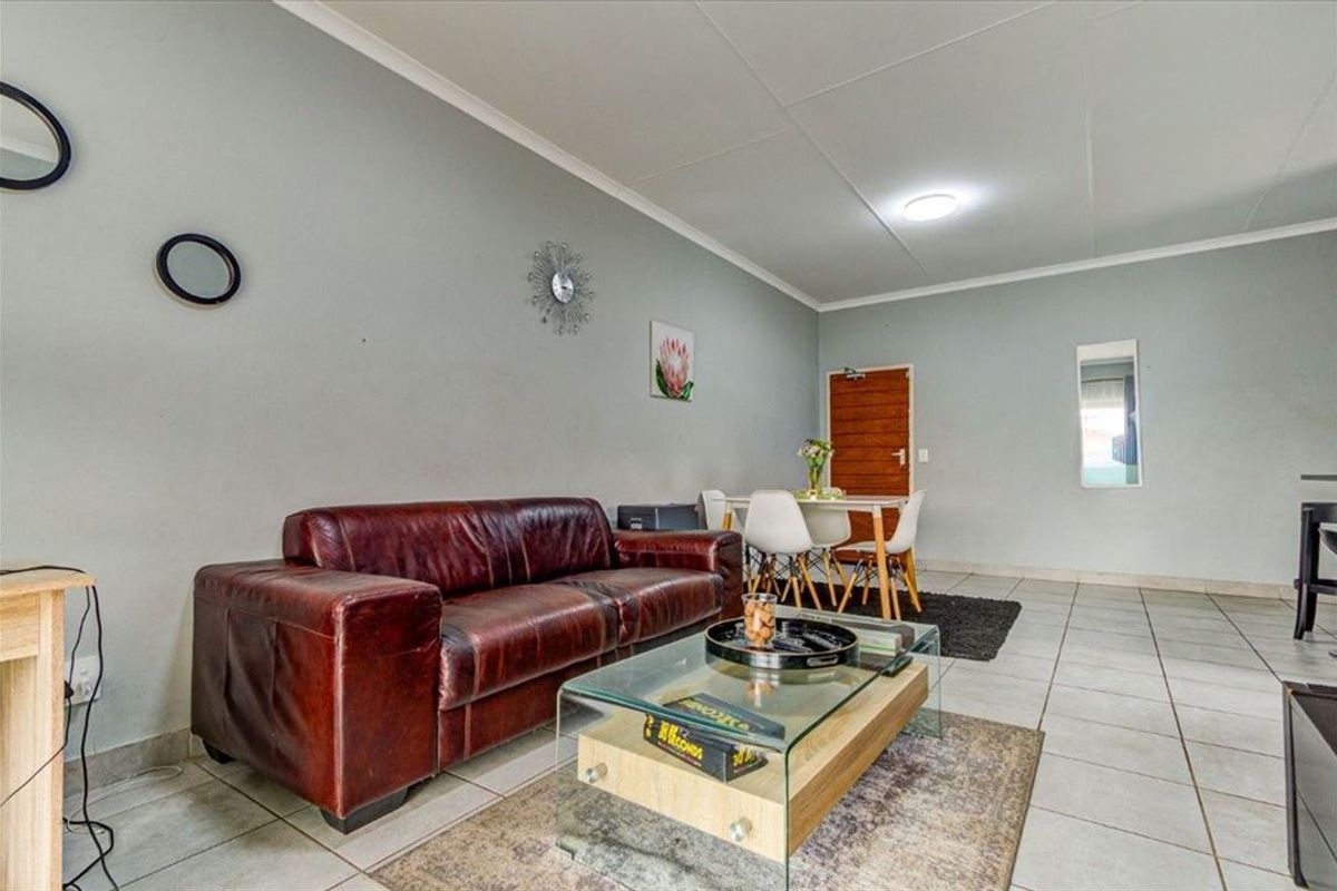 An open-plan living and dining area featuring neutral wall tones, tiled flooring, and a functional layout suitable for comfortable daily living.