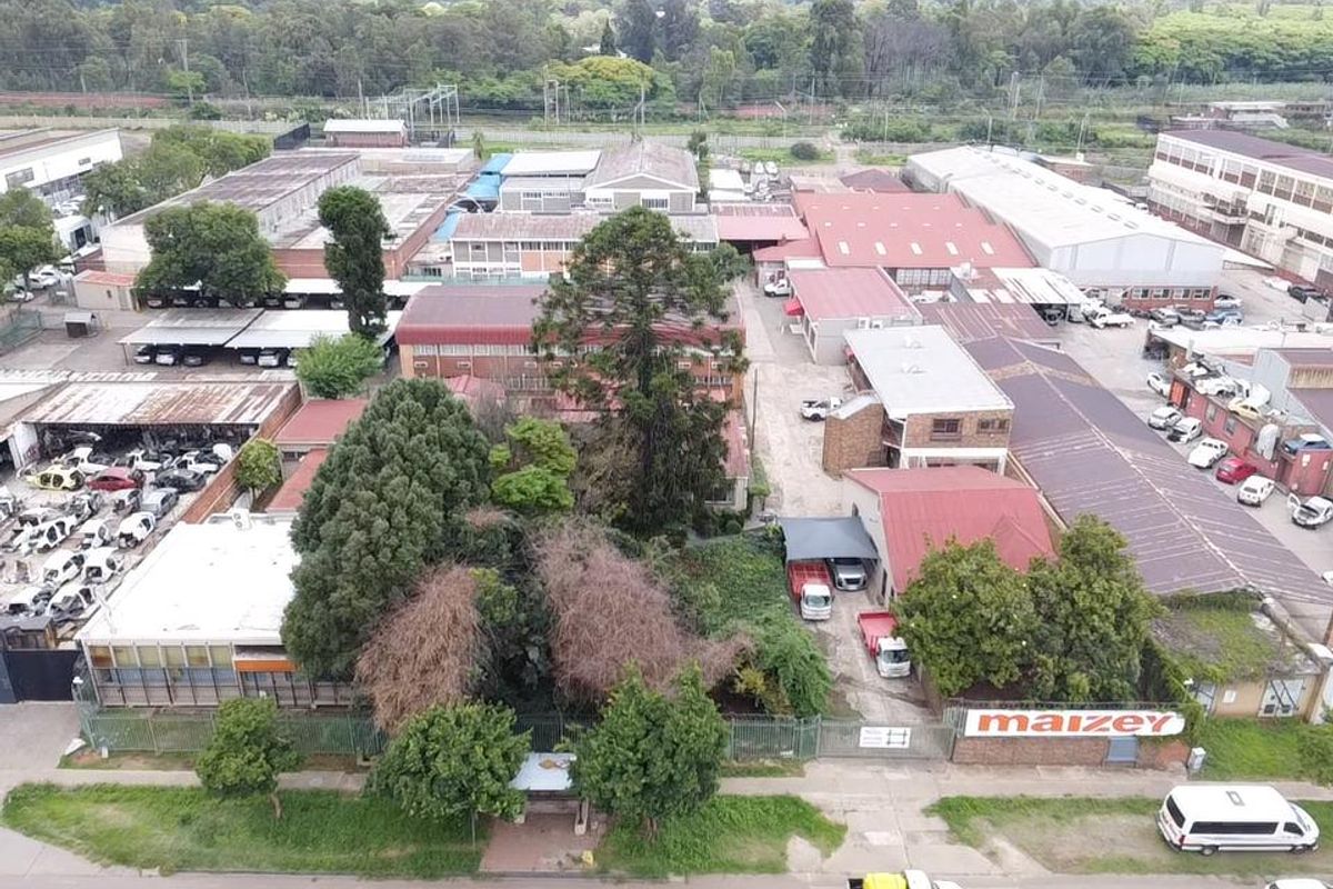 Aerial view of an industrial property complex featuring multiple warehouse structures, paved yard areas, and perimeter fencing.