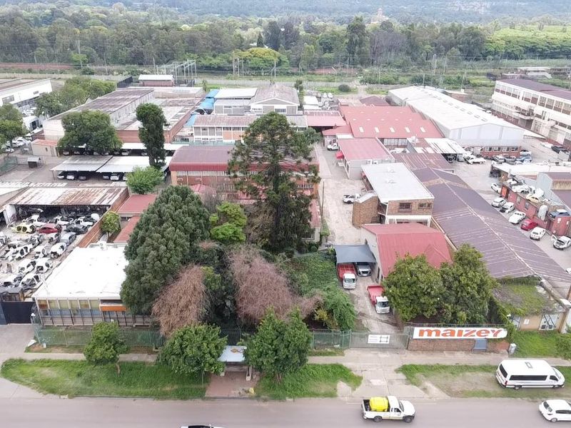 Aerial view of an industrial property complex featuring multiple warehouse structures, paved yard areas, and perimeter fencing.