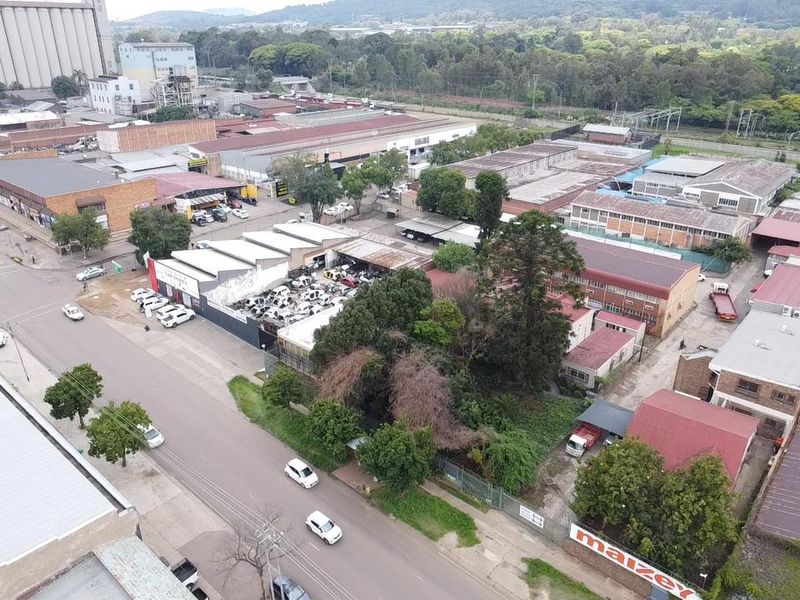 Aerial view of an industrial property featuring multiple warehouse structures, paved access areas, and surrounding commercial infrastructure in an established industrial zone.