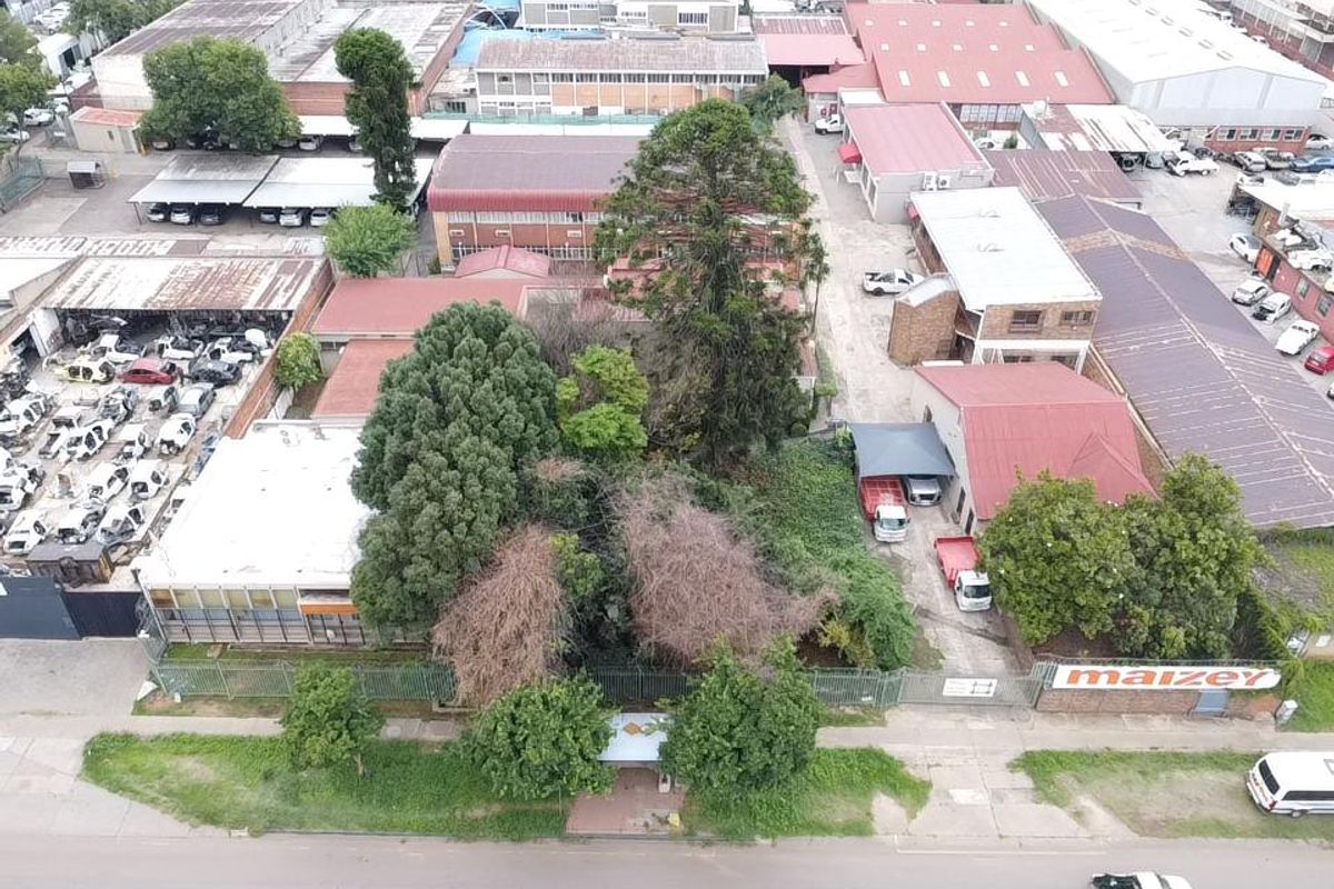 Aerial view of an industrial property complex featuring multiple warehouse buildings, paved yard areas, and perimeter security fencing.