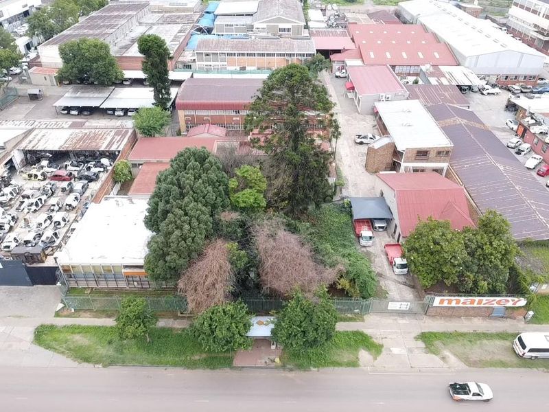 Aerial view of an industrial property complex featuring multiple warehouse buildings, paved yard areas, and perimeter security fencing.