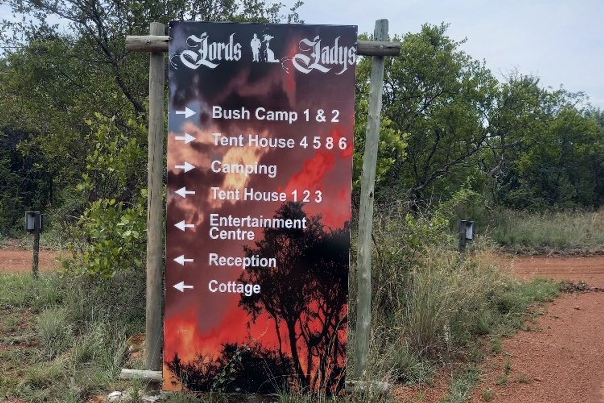A directional signpost located on the farm property, indicating the locations of various accommodation units, camping areas, and the entertainment centre.