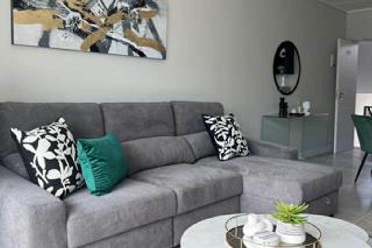 A well-maintained living room featuring neutral wall tones and tiled flooring, providing a comfortable and functional space.