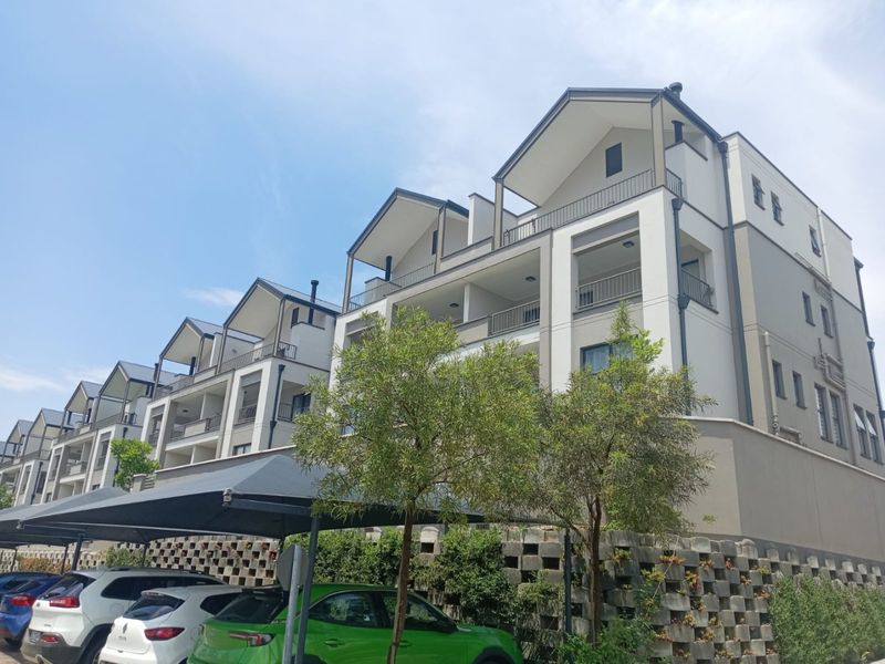 A multi-story apartment complex featuring modern architectural design with private balconies and a dedicated shaded parking area.