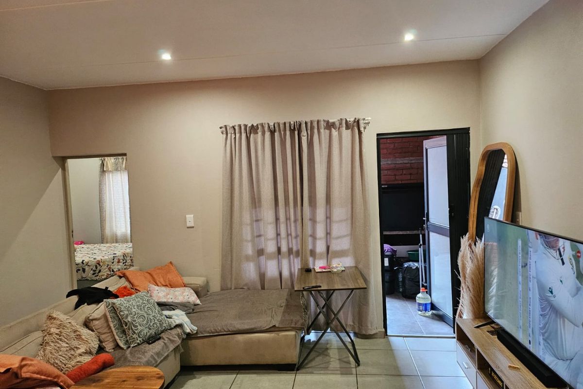 A living room featuring tiled flooring, recessed downlighting, and direct access to an outdoor area through a sliding door.