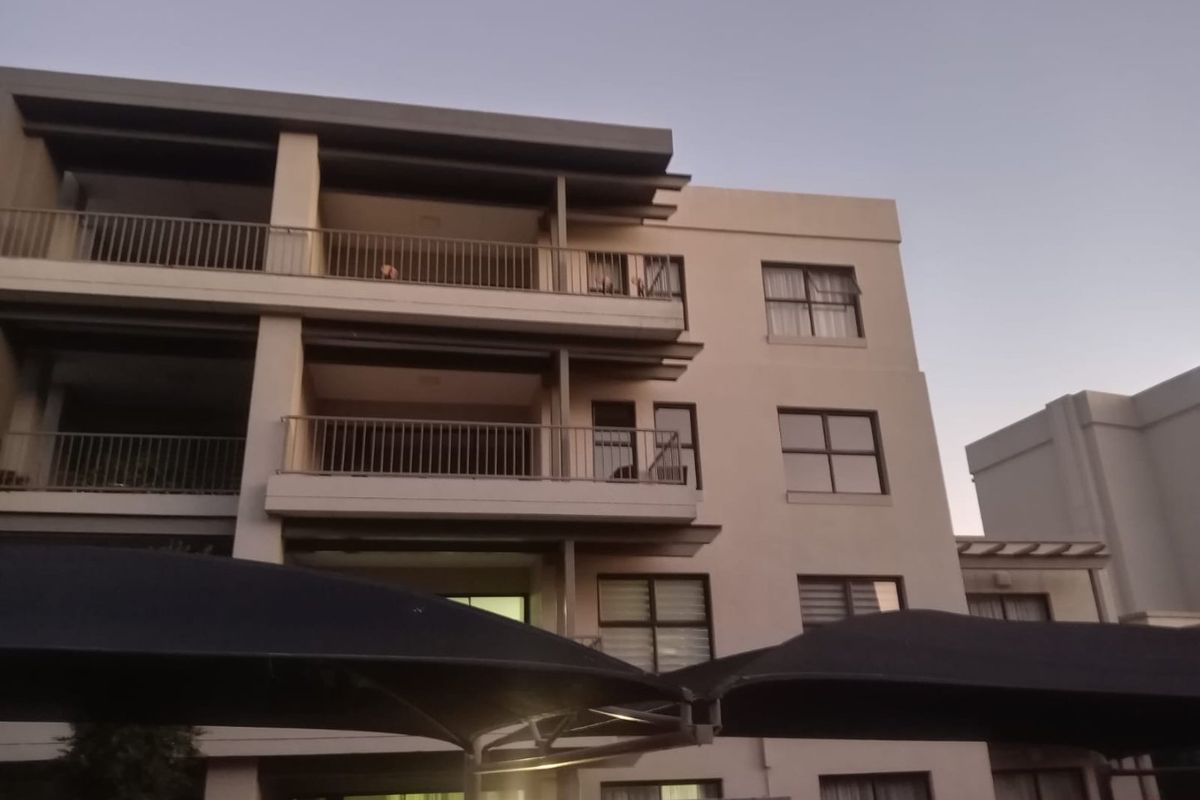 Exterior view of a multi-story apartment building featuring private balconies with metal railings and modern aluminium window frames.