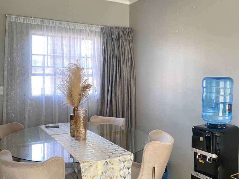 A dining area featuring tiled flooring and coving, with visible wall surface imperfections requiring minor repair.