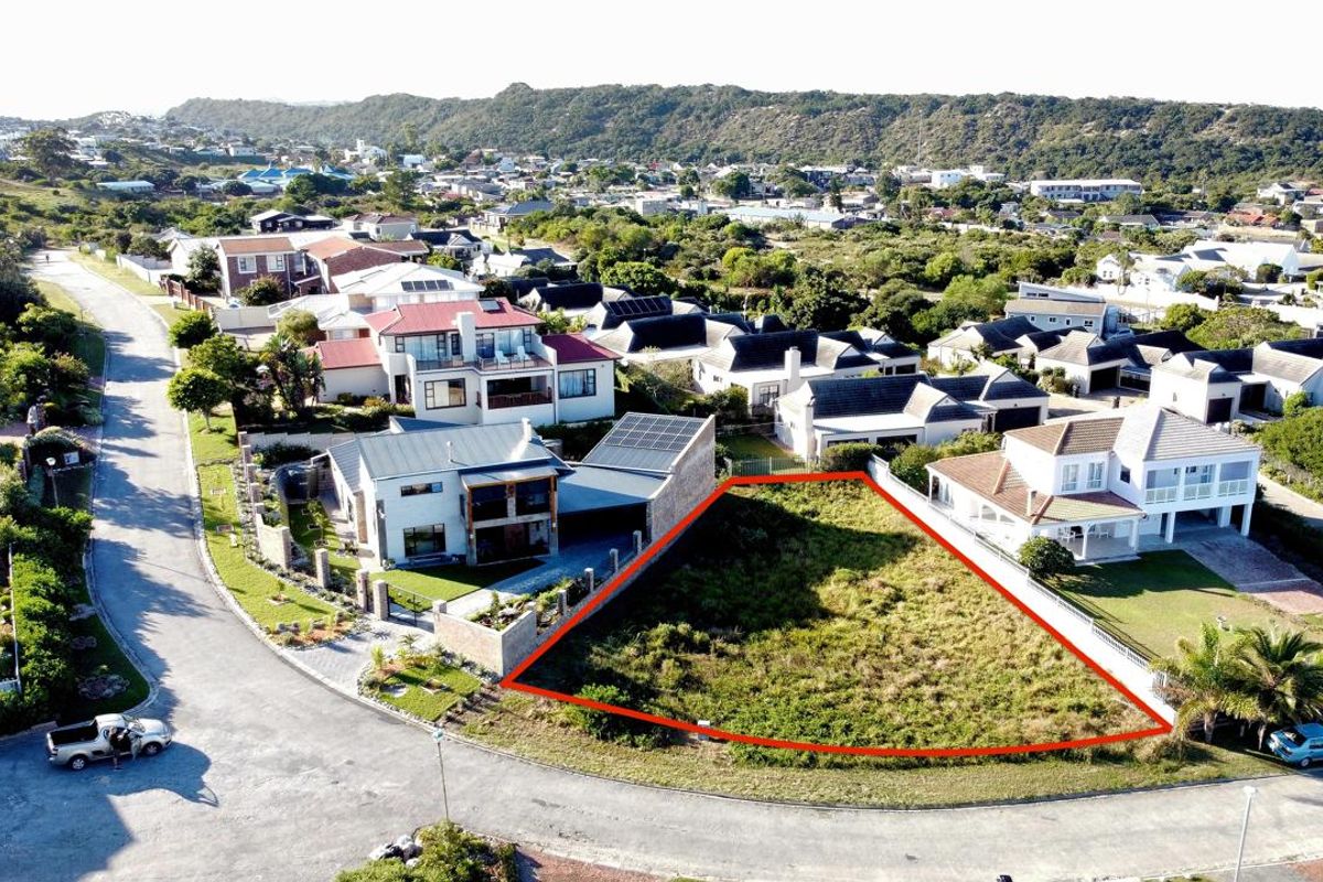 An aerial view of a vacant residential plot in a developed coastal neighborhood, highlighting the property boundaries and surrounding residential infrastructure.