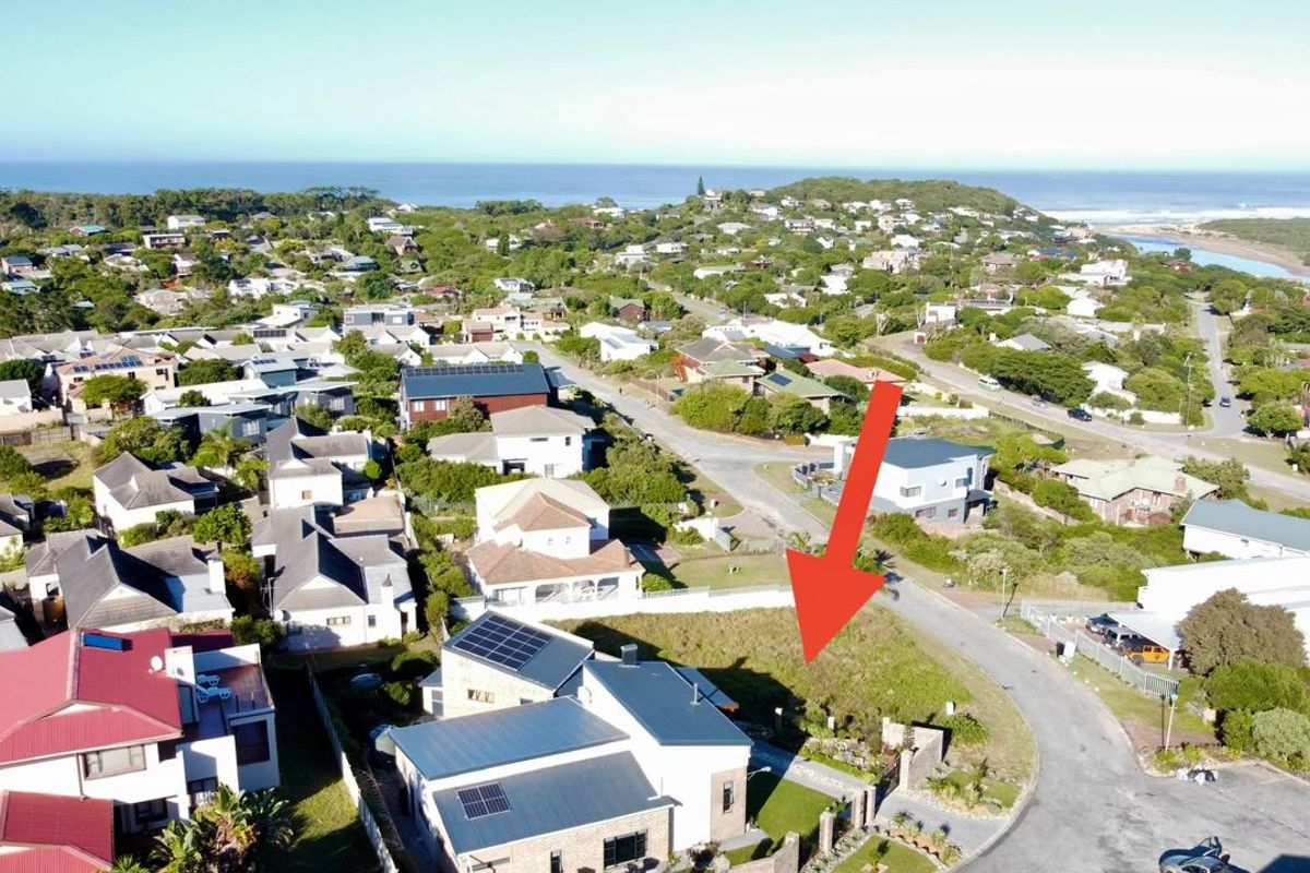 Aerial view of a vacant residential plot in a coastal neighborhood, highlighting the available land and surrounding community infrastructure.