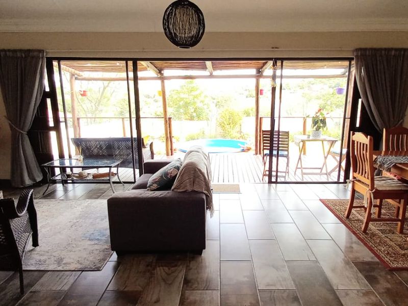 Spacious open-plan living and dining area featuring large sliding glass doors that provide seamless access to the outdoor patio and pool area.