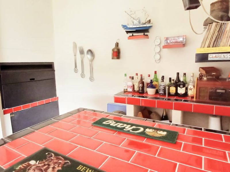A dedicated bar area featuring a built-in tiled counter and a built-in fireplace, offering a functional space for entertaining.