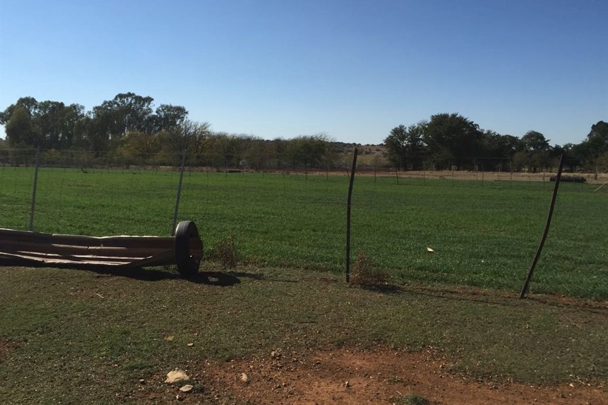 Expansive open pasture land featuring wire perimeter fencing, suitable for agricultural or livestock use.
