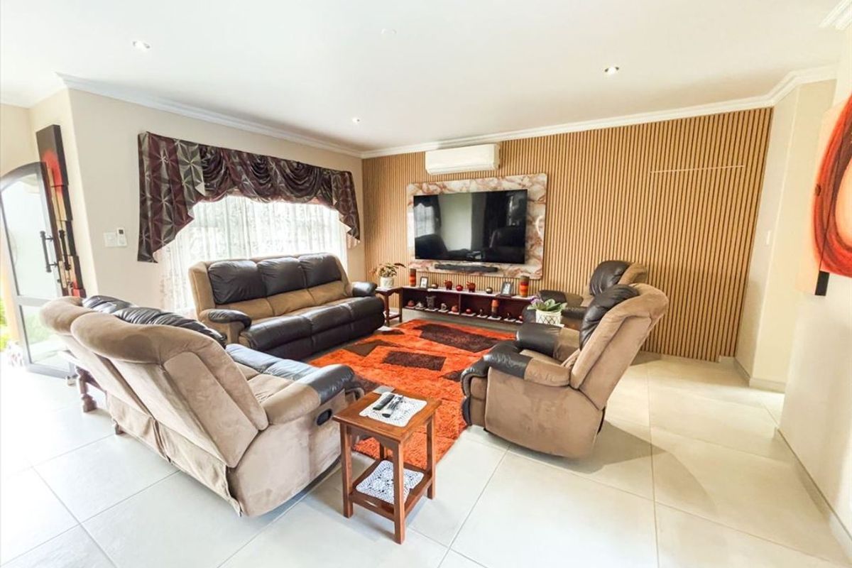 Spacious living room featuring a modern timber slat feature wall, tiled flooring, and a split system air conditioner.