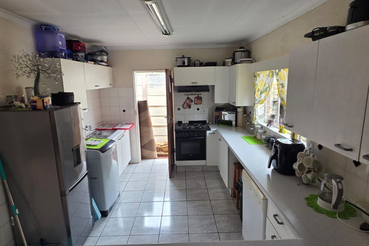 Functional kitchen featuring tiled flooring, built-in cabinetry, a built-in oven with extractor fan, and direct access to the exterior.