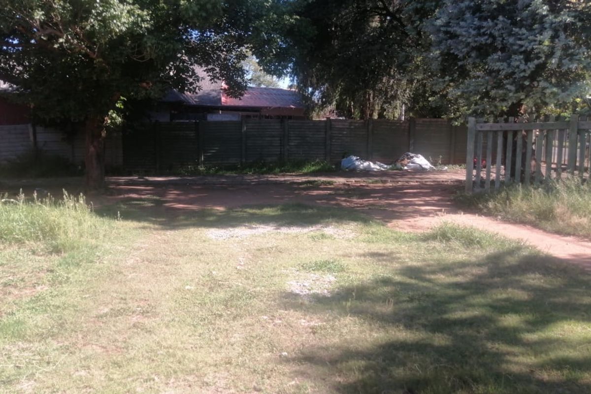 A rear garden area featuring a timber fence and boundary wall, currently requiring landscaping and maintenance to improve the outdoor space.