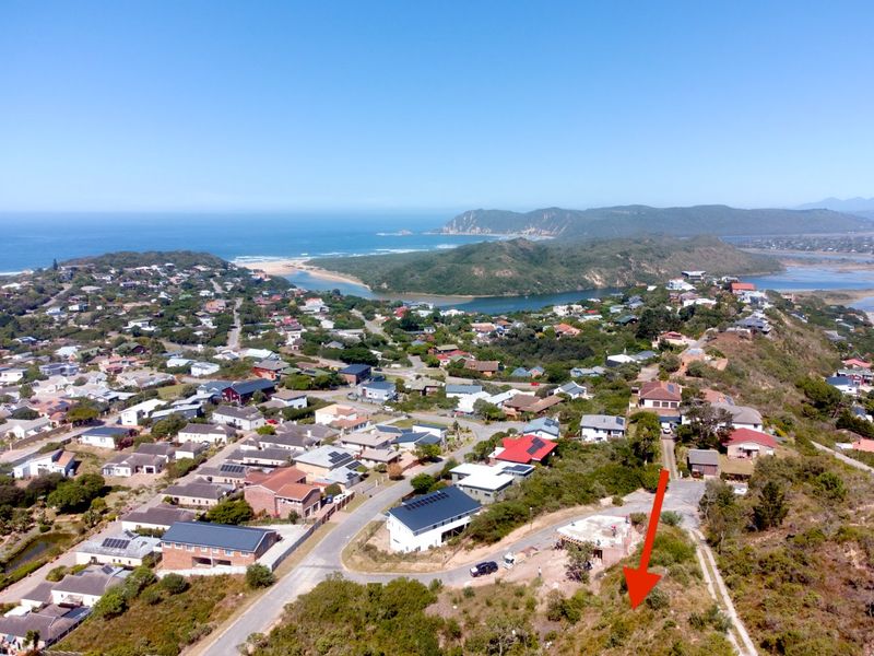 Aerial view of a vacant residential plot situated in a coastal neighborhood with scenic views of the surrounding landscape and ocean.
