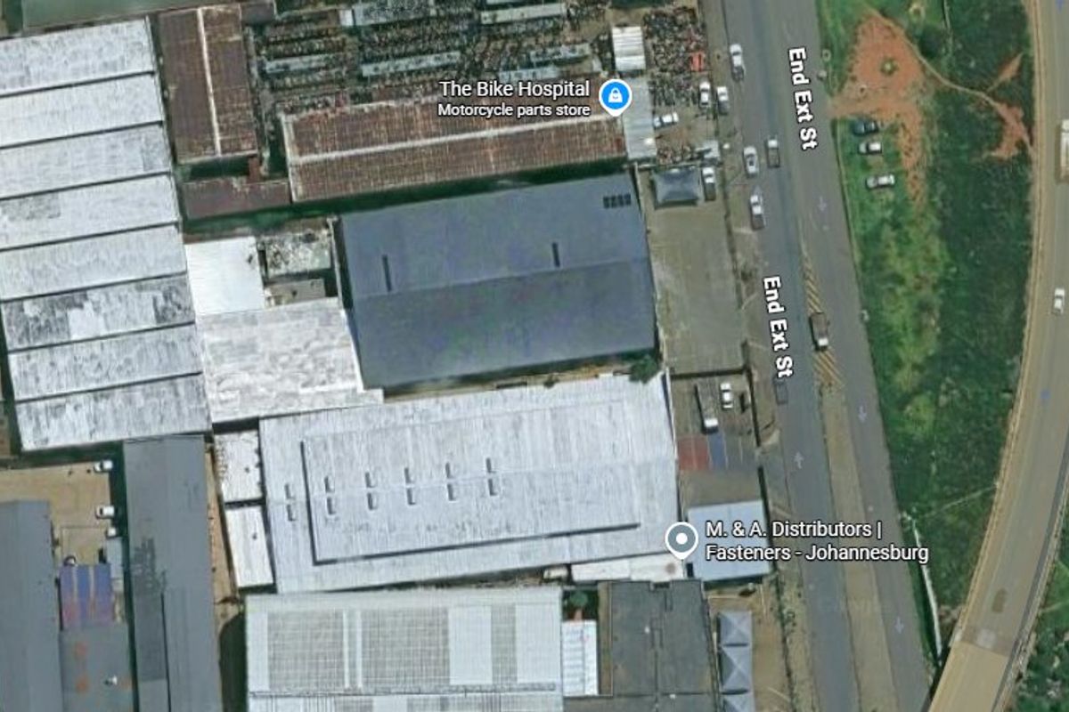 Aerial view of an industrial property complex featuring multiple warehouse structures with metal roofing and paved access areas.