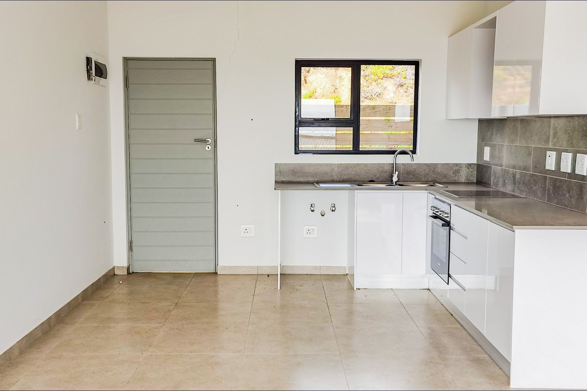 Modern kitchen featuring white cabinetry, tiled splashbacks, built-in oven, and tiled flooring, offering a clean and functional space.