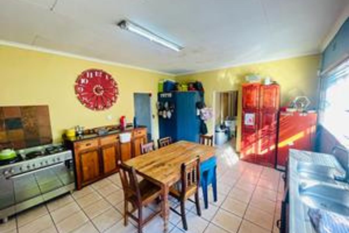 Spacious farm-style kitchen featuring a gas stove, double basin sink, and tiled flooring, offering a functional layout with ample cabinetry.