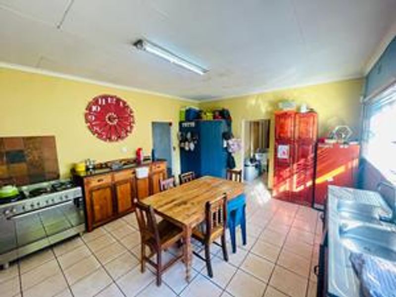 Spacious farm-style kitchen featuring a gas stove, double basin sink, and tiled flooring, offering a functional layout with ample cabinetry.
