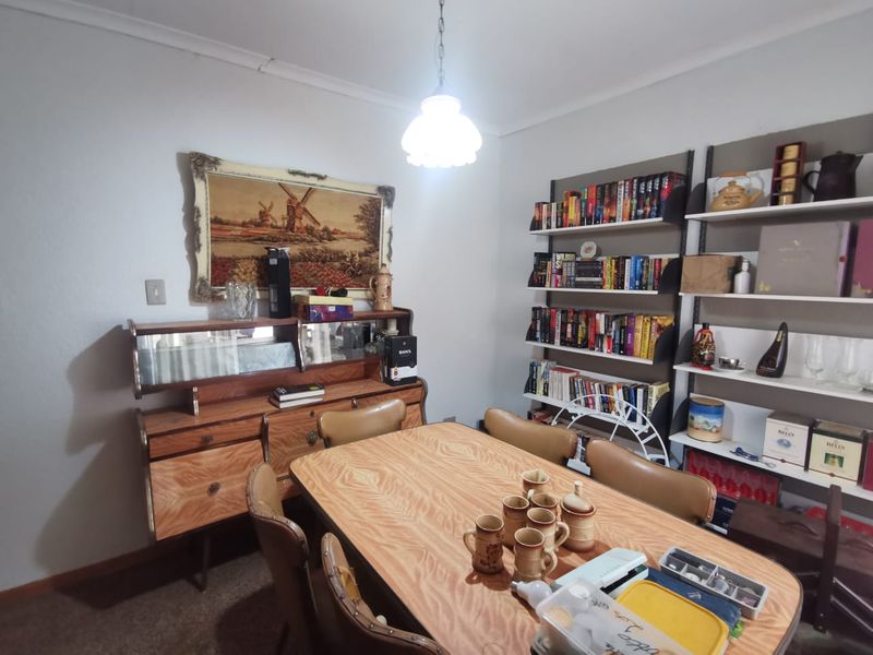 A dining room featuring built-in shelving units and a central pendant light fixture.