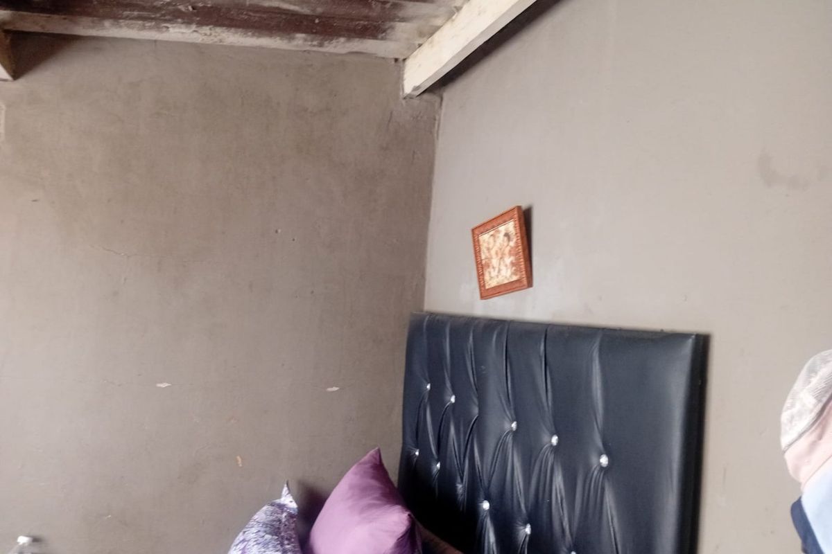 A bedroom space featuring exposed timber ceiling beams and unfinished wall surfaces, requiring cosmetic updates to improve the overall finish and aesthetic appeal.
