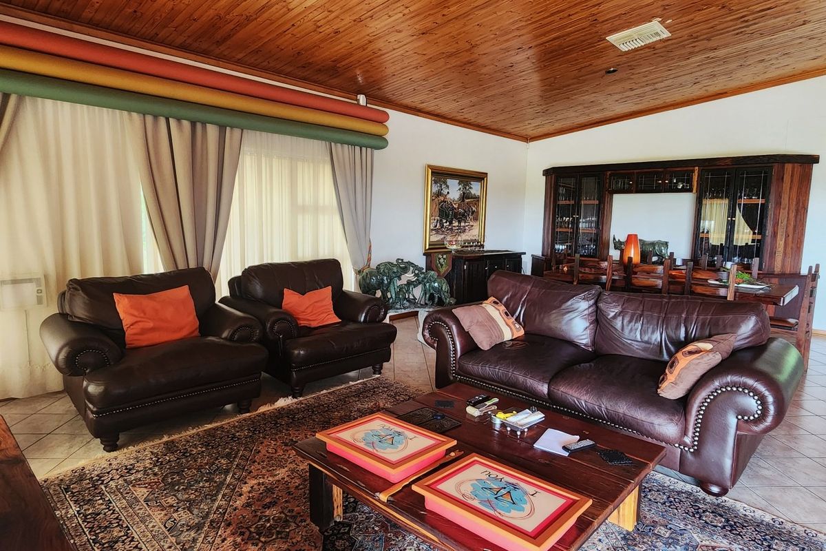 Spacious living room featuring a warm timber tongue and groove ceiling, tiled flooring, and integrated built-in display cabinetry.