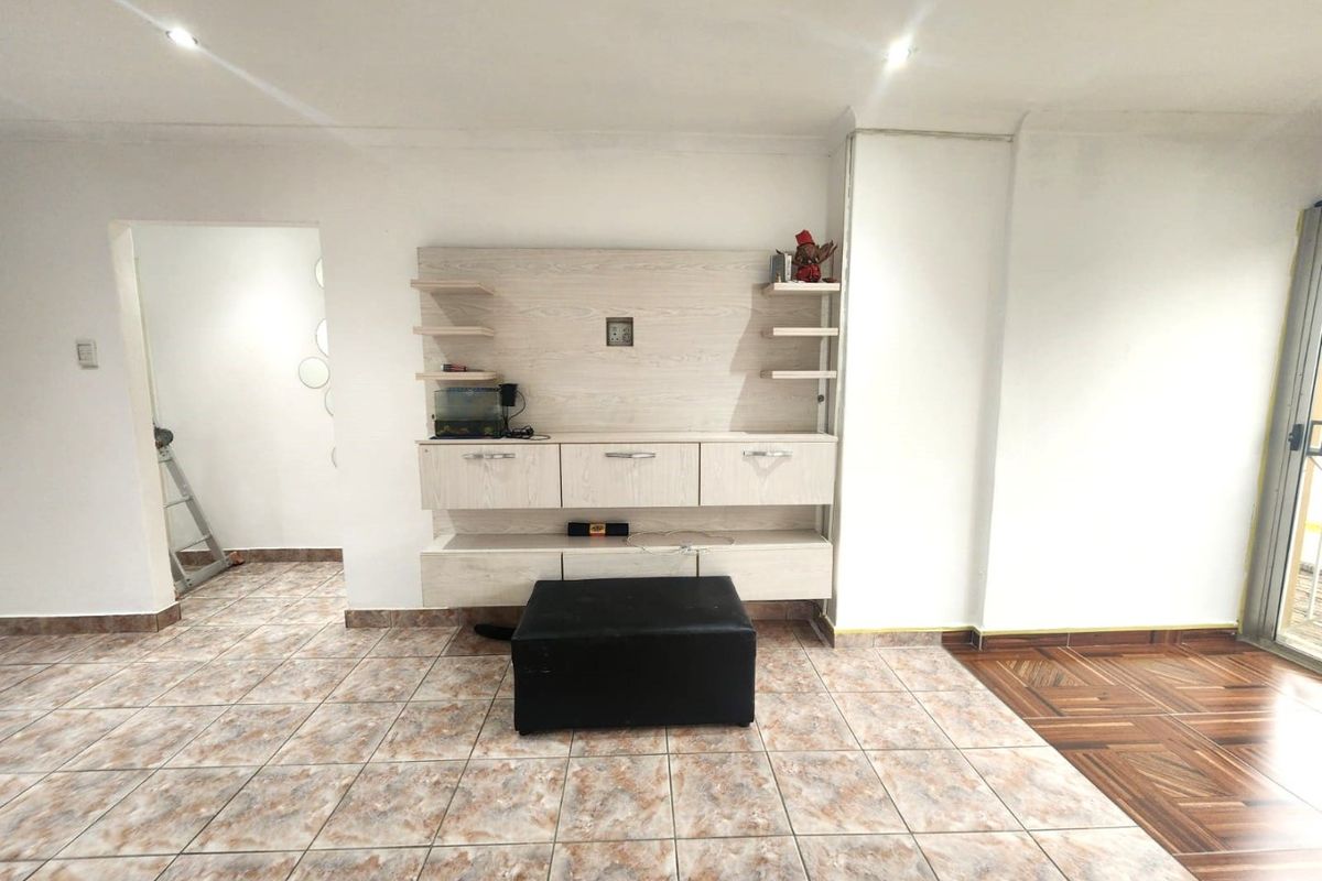 Living room featuring built-in cabinetry, recessed lighting, and tiled flooring with a transition to wood-look flooring.