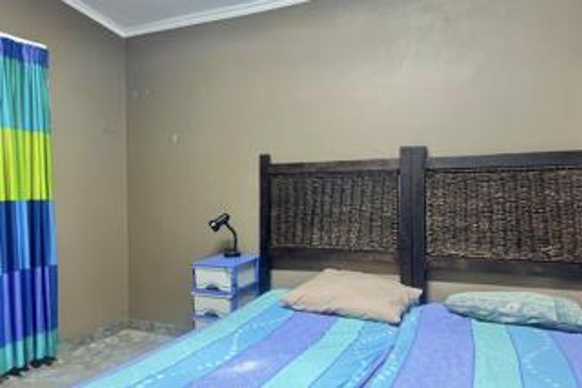 A bedroom featuring tiled flooring and neutral wall paint, currently requiring minor cosmetic updates to the wall surfaces.