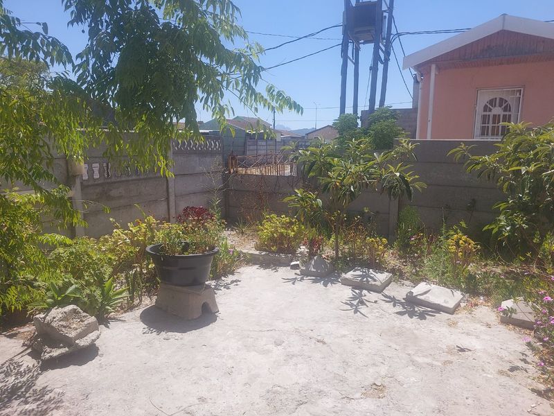 A modest rear garden area featuring a concrete patio slab and precast concrete boundary walls, offering potential for landscaping and outdoor improvement.