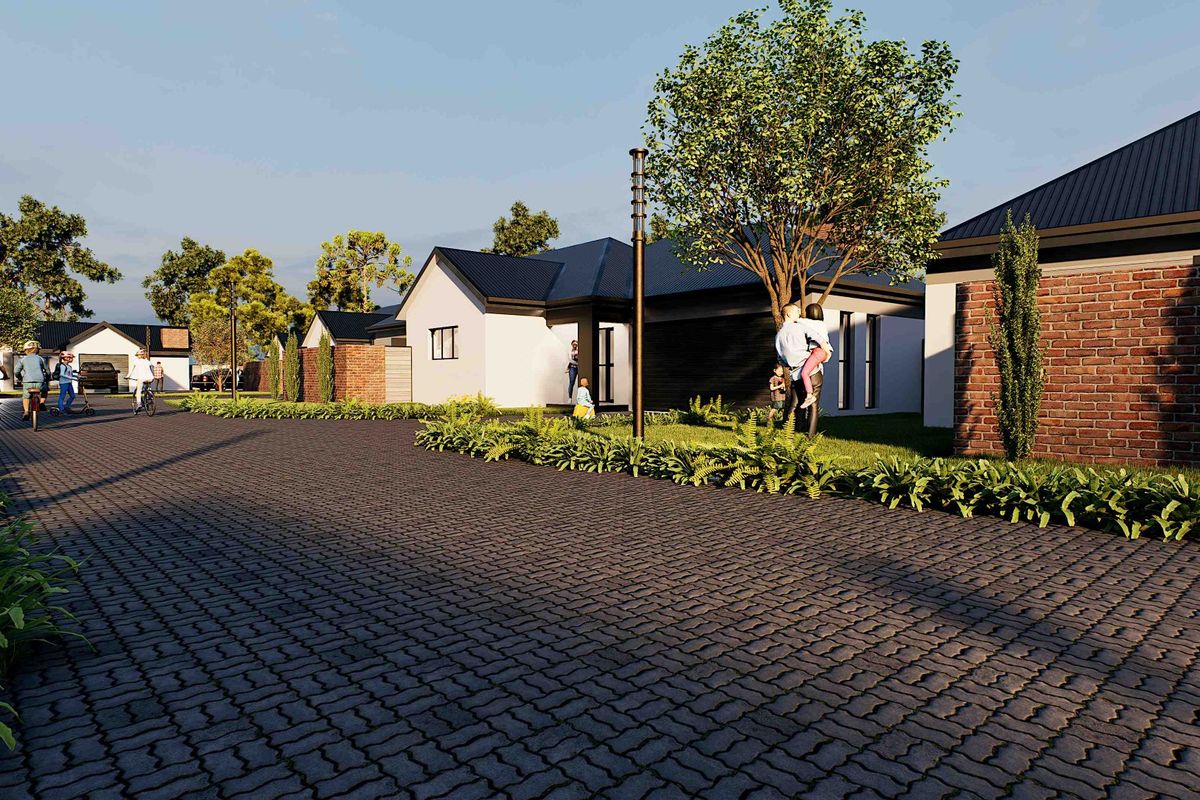 A street-level view of a modern residential development featuring paved driveways, brick and rendered facades, and well-maintained landscaped gardens.
