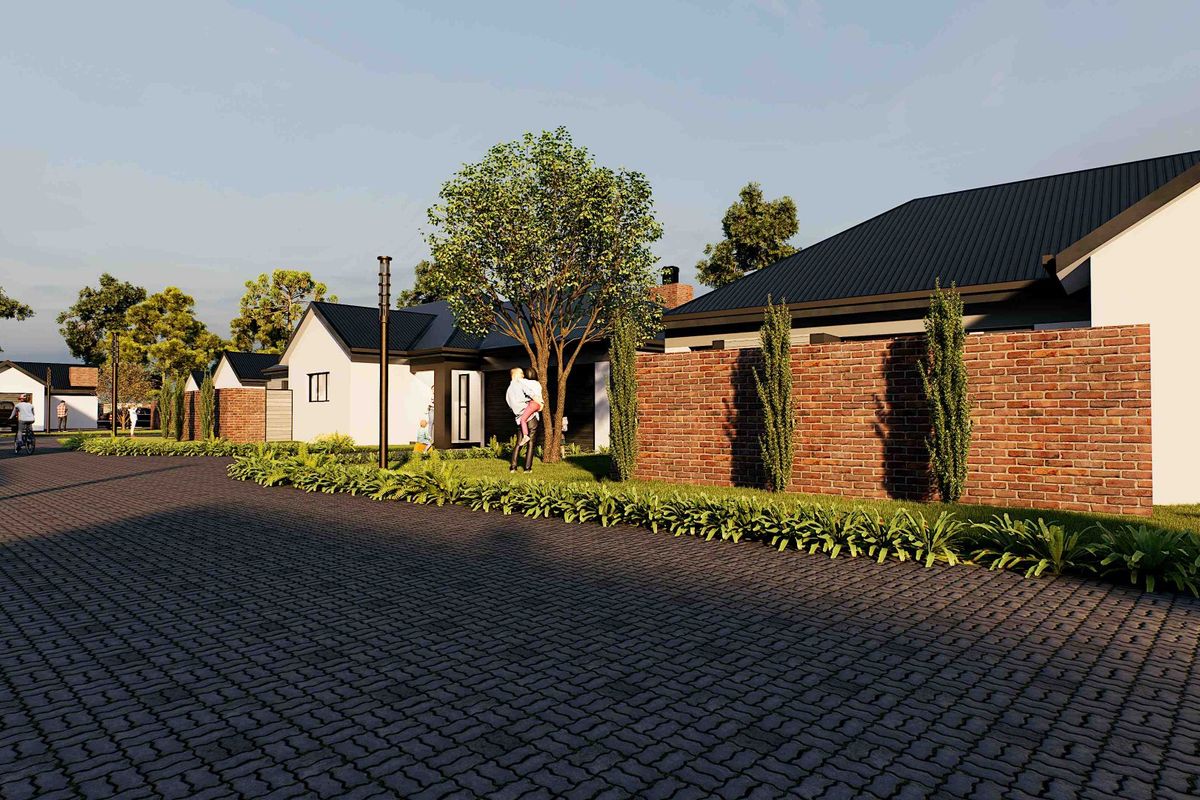 A street-level view of a modern residential development featuring paved roads, brick boundary walls, and contemporary homes with metal roofing.
