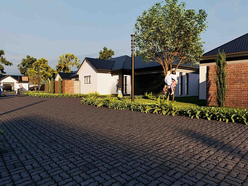 A street-level view of a modern residential development featuring paved driveways, brick and rendered facades, and well-maintained landscaped gardens.