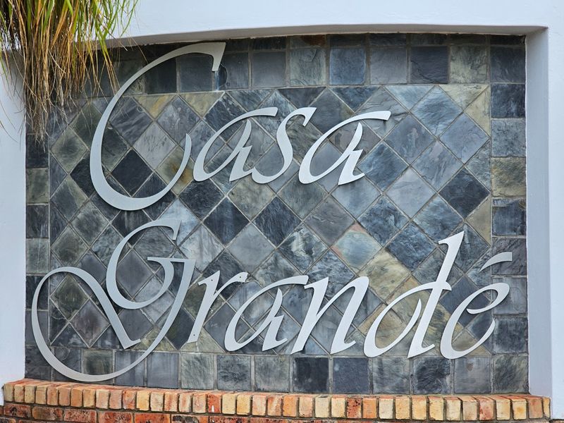 A close-up view of the Casa Grande property signage featuring decorative stone cladding and a brick base.